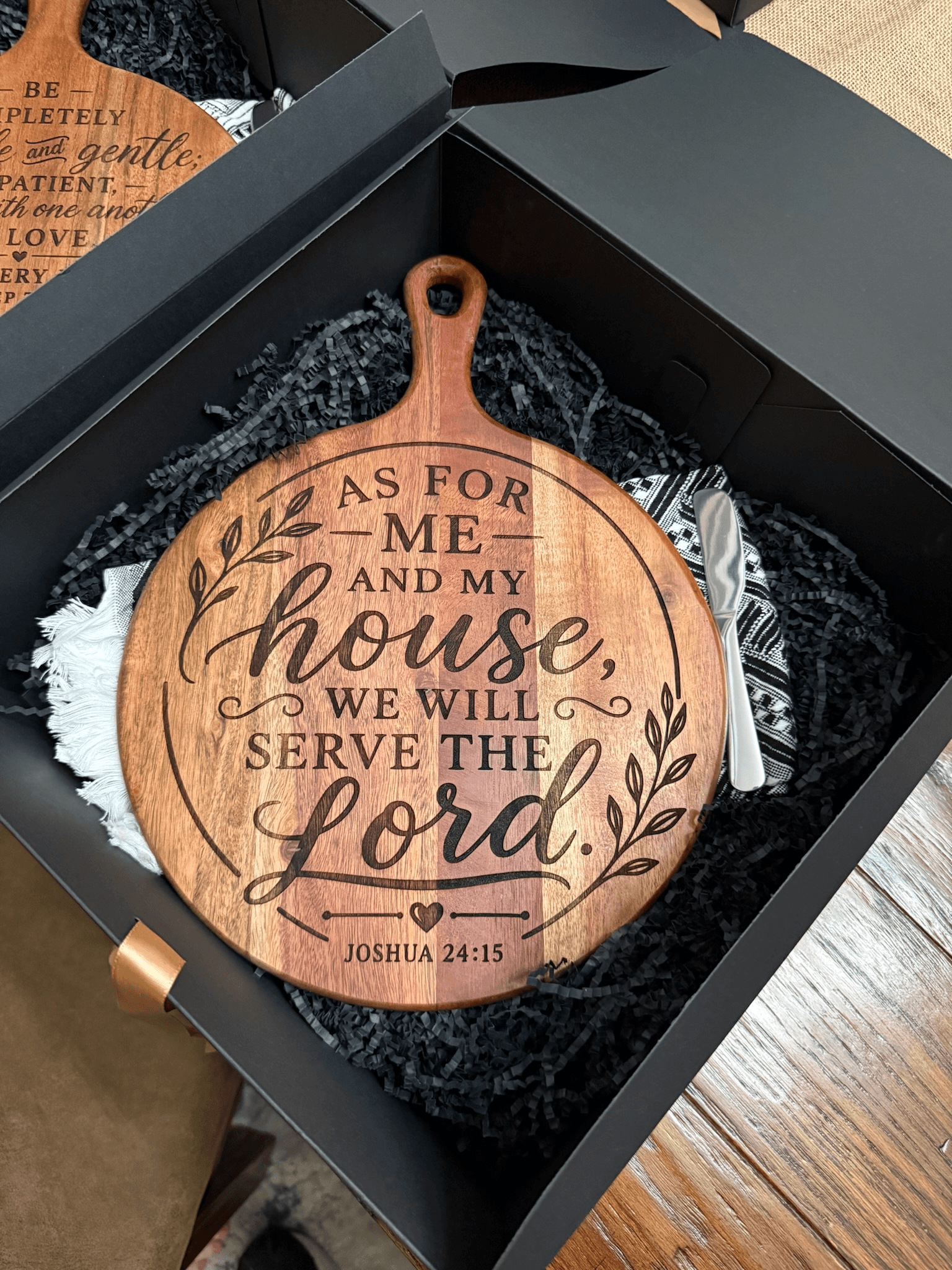 Engraved wooden cutting board with Joshua 24:15 inside a black gift box with accessories.
